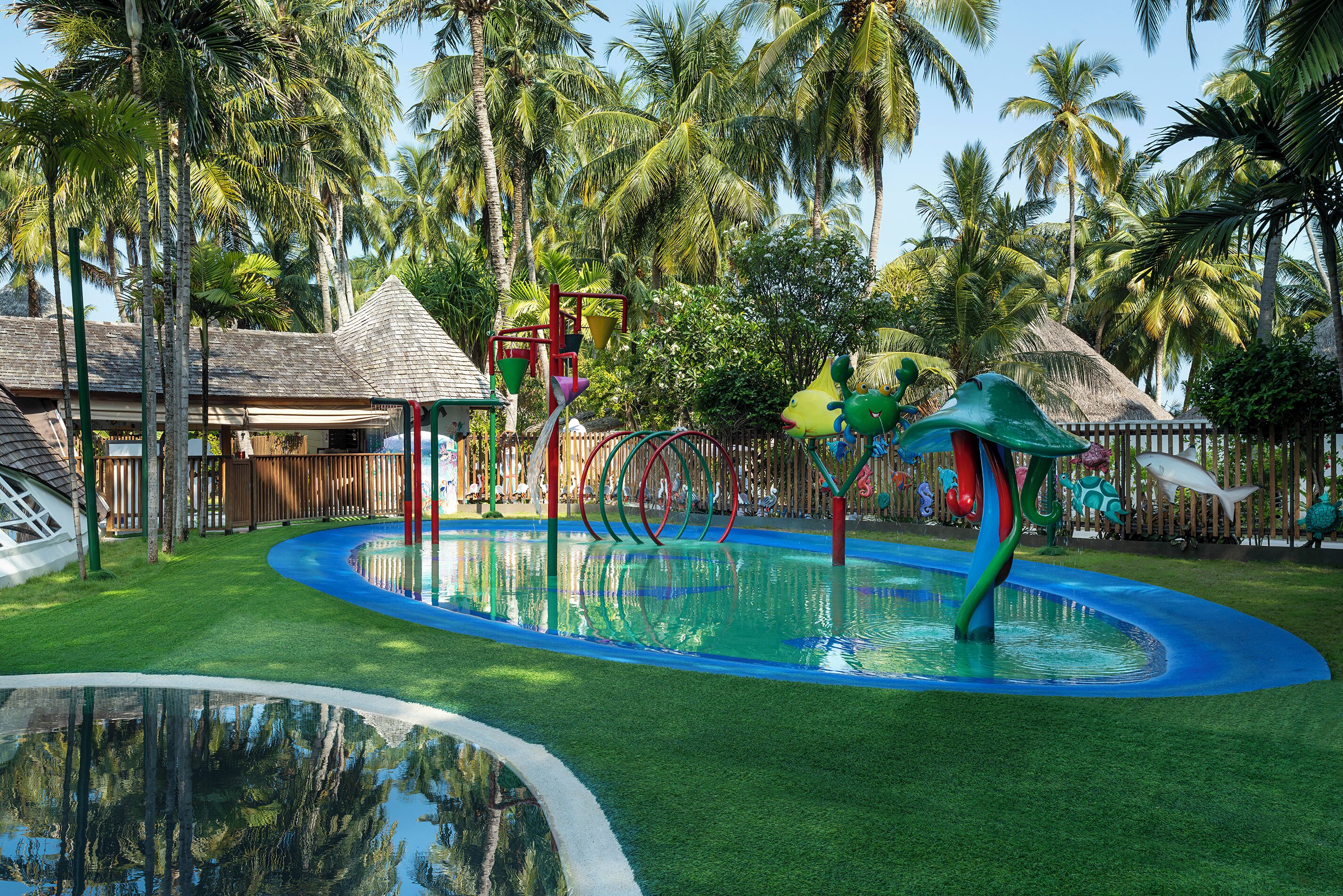 A water park with slides, a pool, and tropical vegetation.