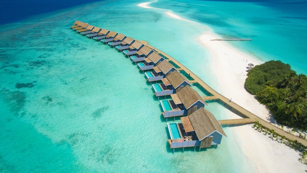 An overwater bungalow resort with a long pier connecting to the beach. - Niva Kuramathi Maldives (Kuramathi Island)