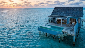 An overwater bungalow with a deck, a pool, and a view of the ocean. - Niva Kuramathi Maldives (Kuramathi Island)