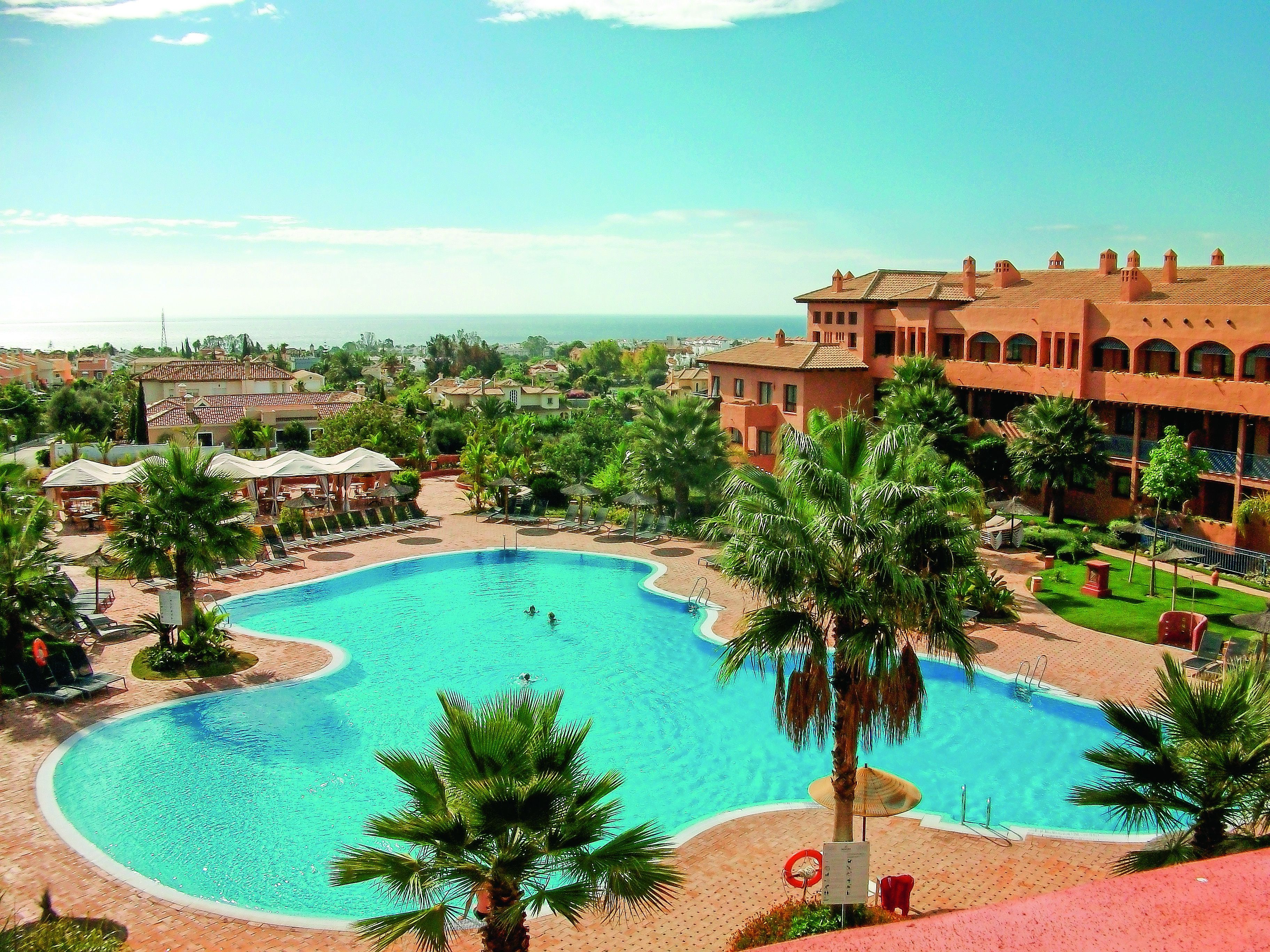 Una piscina al aire libre, sombrillas