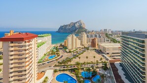 A coastal hotel with multiple buildings, a large mountain in the background, and a central swimming area. - Apartamentos Coral Beach (Calpe)