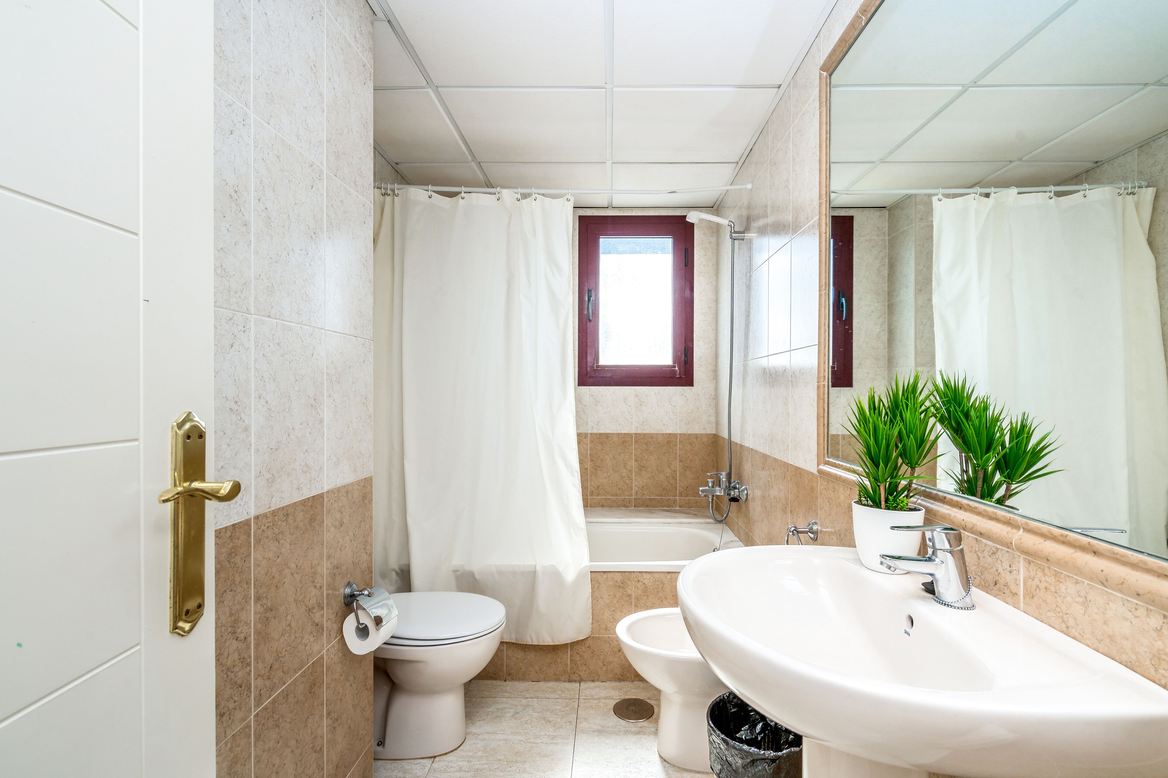 A bathroom with a toilet, bidet, bathtub, and sink.