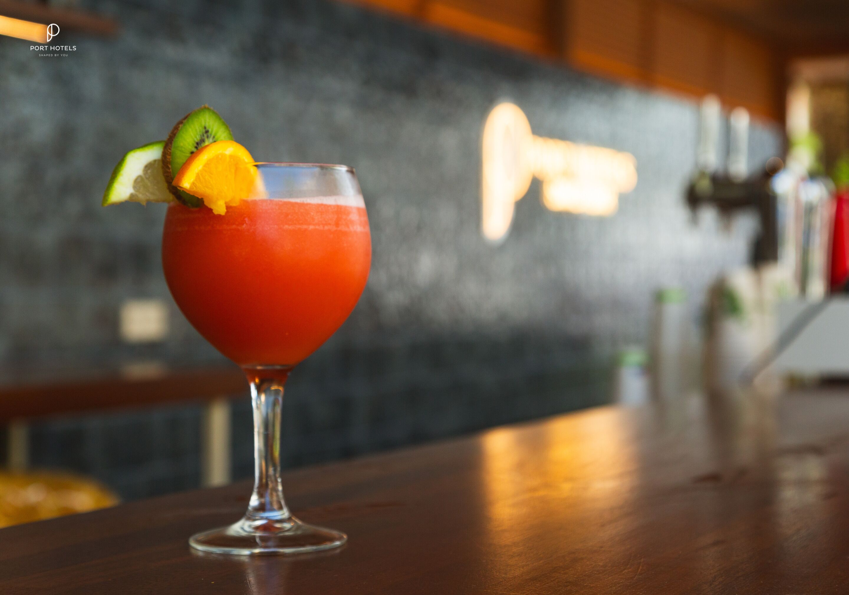 A cocktail with fruit garnish on a bar counter.