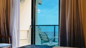 A hotel room with a bed, a chair, and a balcony with a chair. - Port Denia Hotel (Denia)