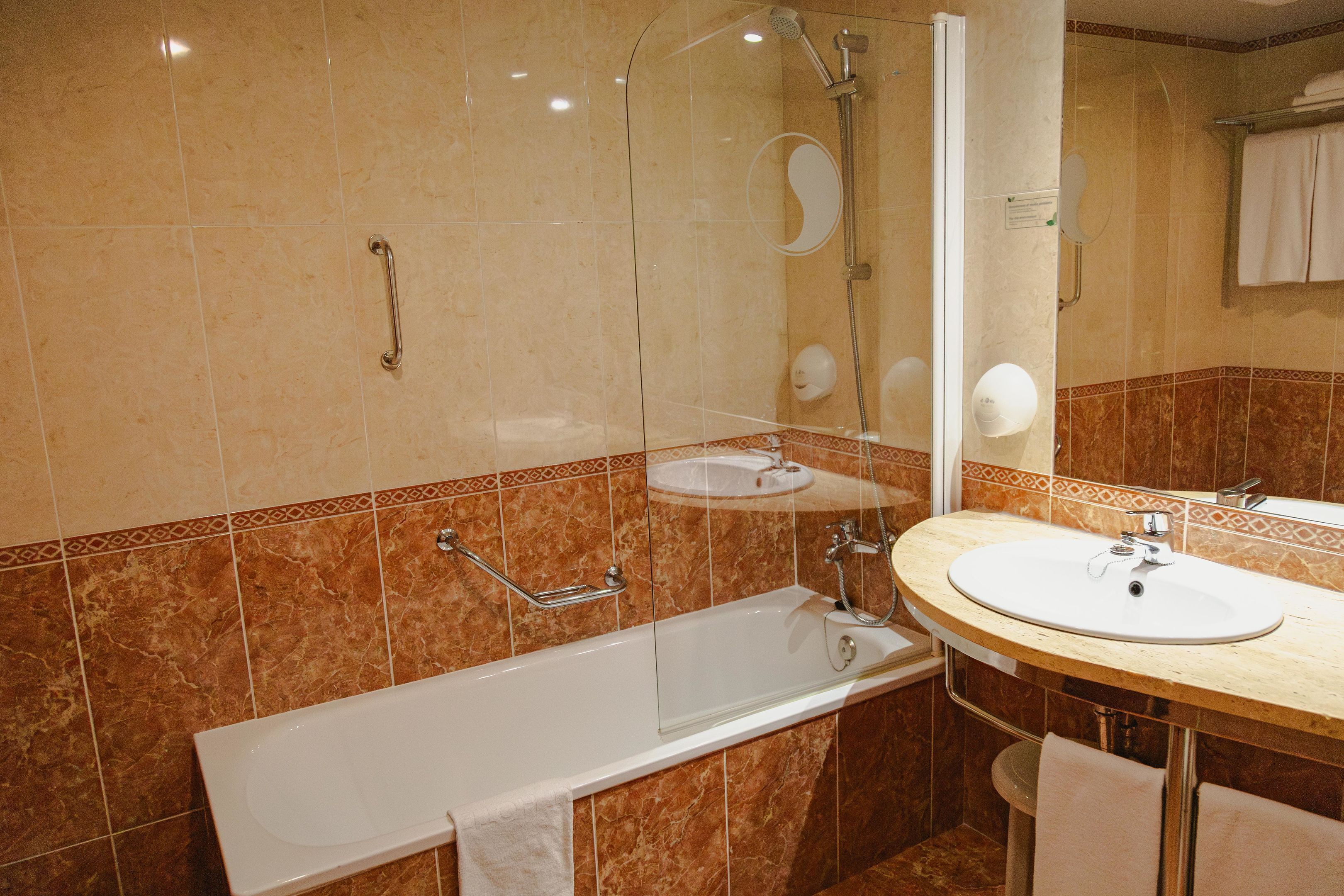 A bathroom with a bathtub, a sink, and a shower.