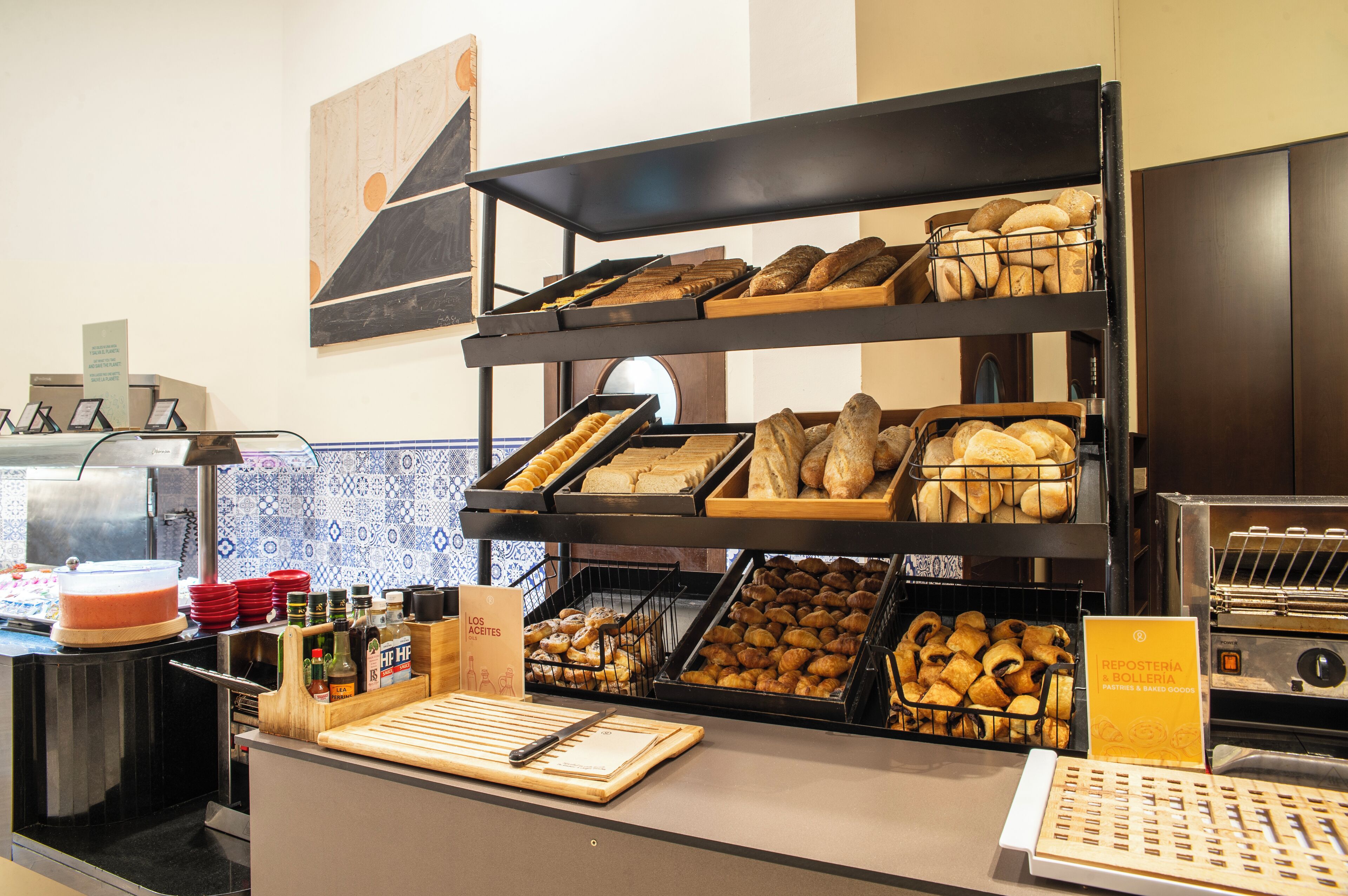 A bakery display with various baked goods, a cutting board, and a sign indicating a bakery section.