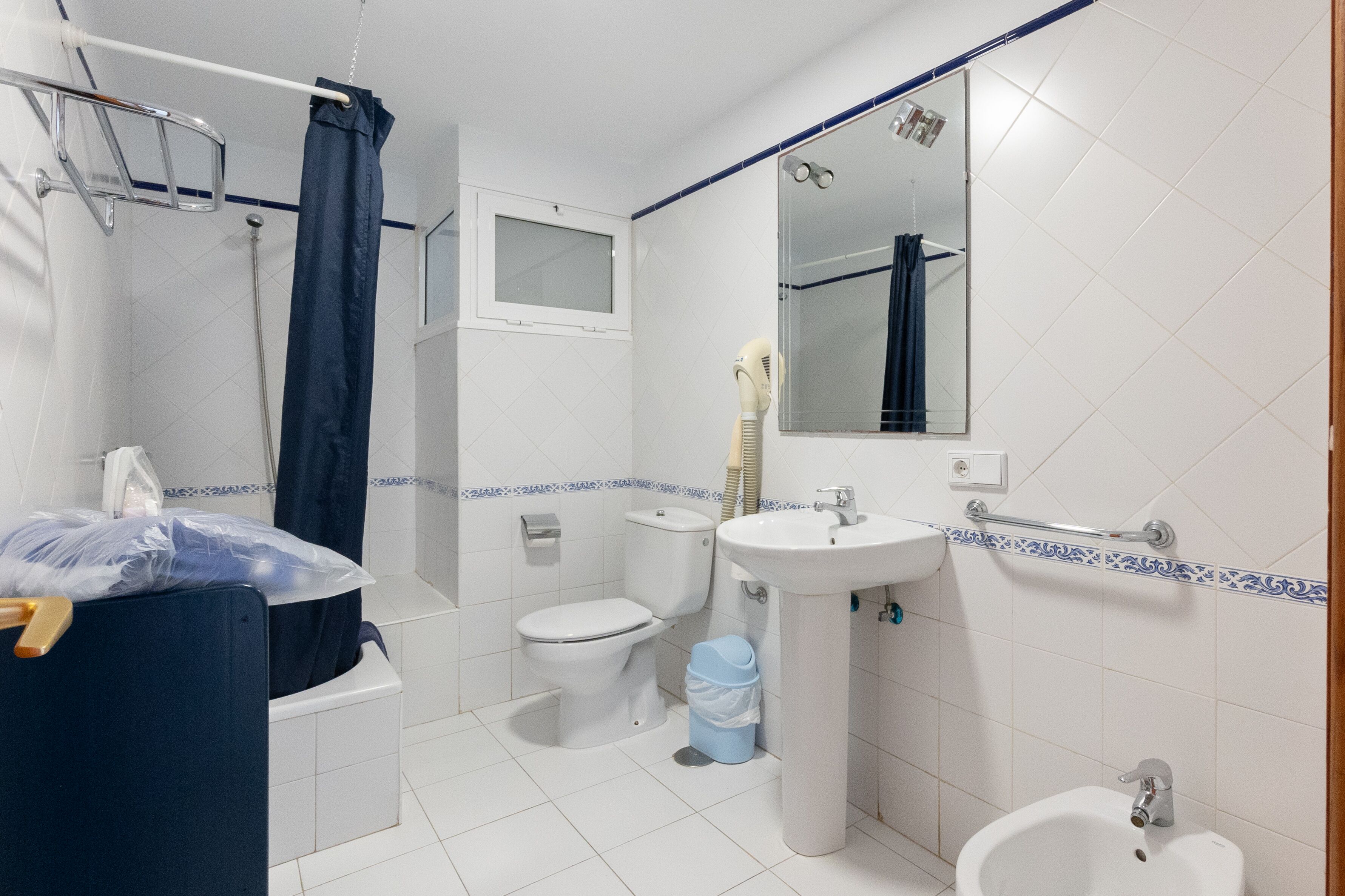 Un baño con ducha, inodoro, lavamanos y bidé.