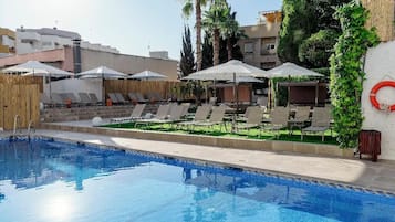 Piscina a l'aire lliure, para-sols i gandules