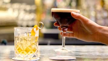 Dos vasos de bebidas sobre una barra.