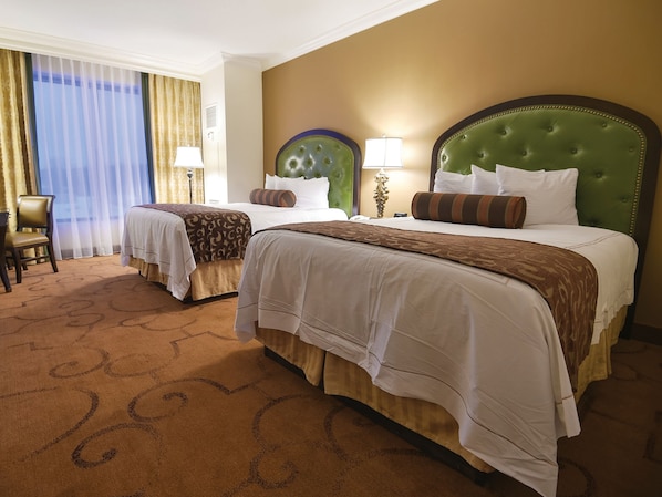 A hotel room with two beds, a chair, and a large window with curtains. - Belterra Casino Resort (Florence)