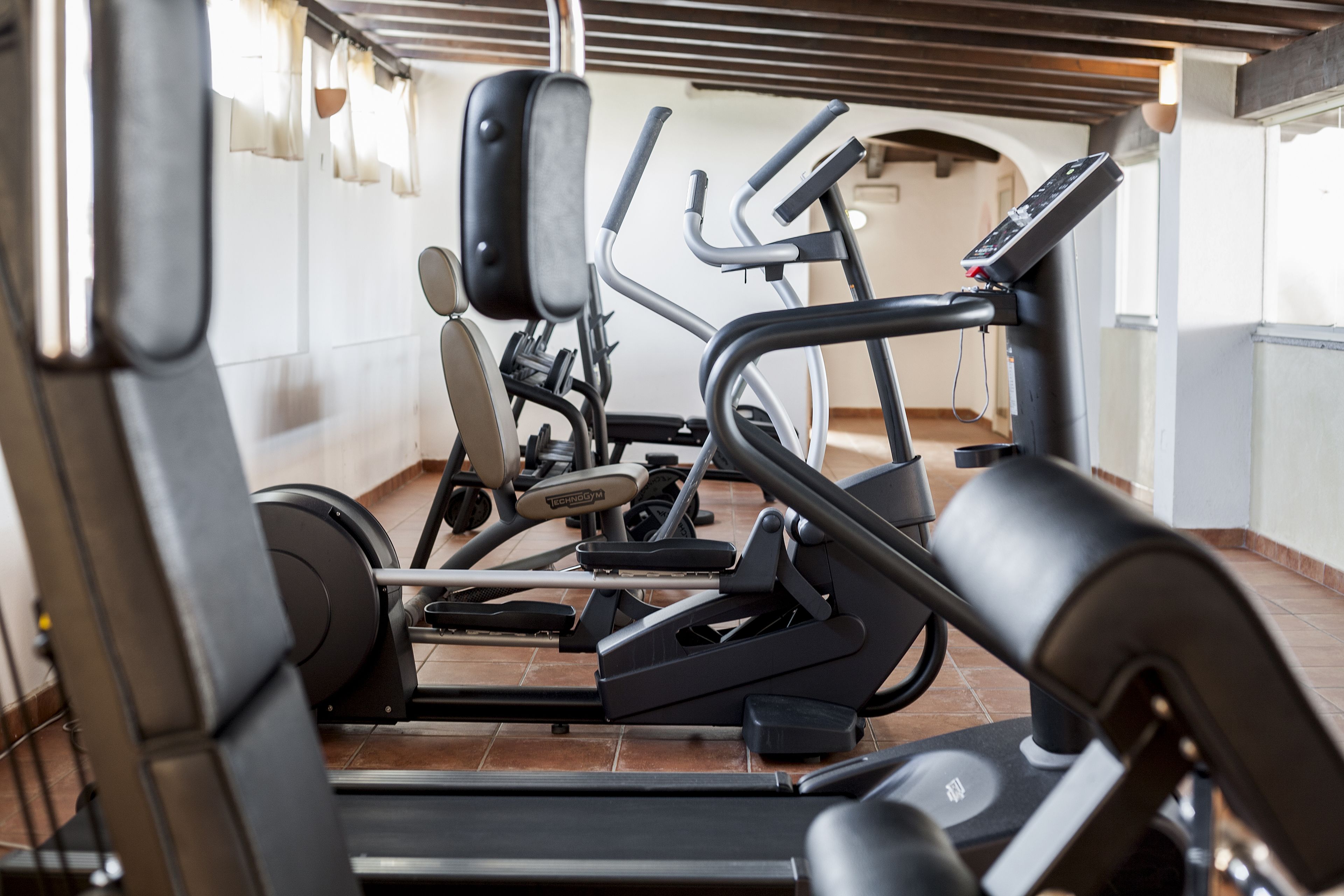 A gym with various exercise machines, including treadmills and weight machines.