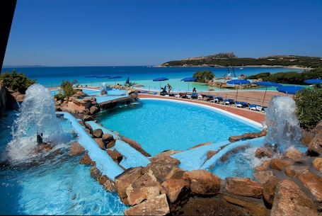 2 piscine all'aperto, lettini. COLONNA GRAND HOTEL CAPO TESTA, a Colonna Luxury Beach Hotel, Santa Teresa Sardegna