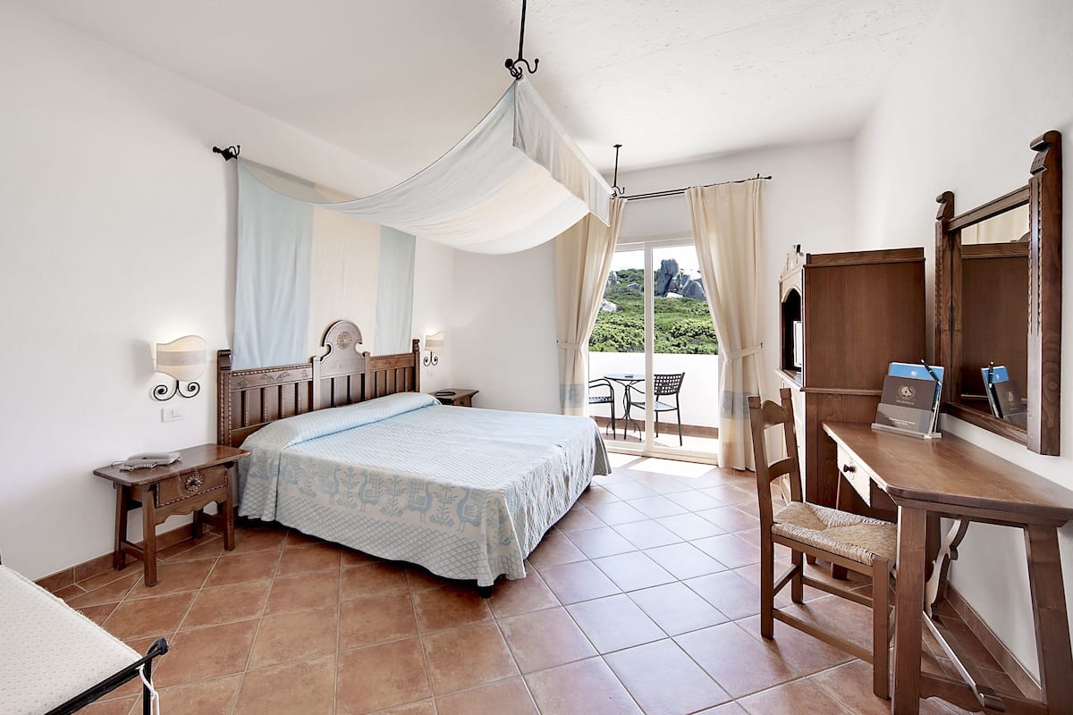 Une chambre à coucher avec un lit, des tables de chevet, un bureau et une chaise.