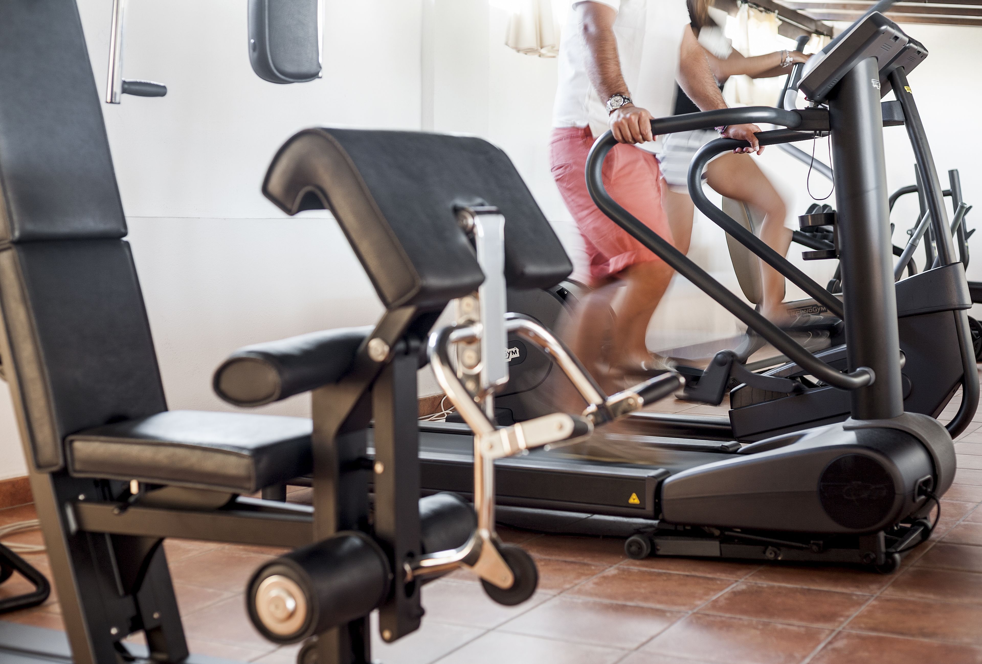 A gym with exercise equipment, including treadmills and weight machines.