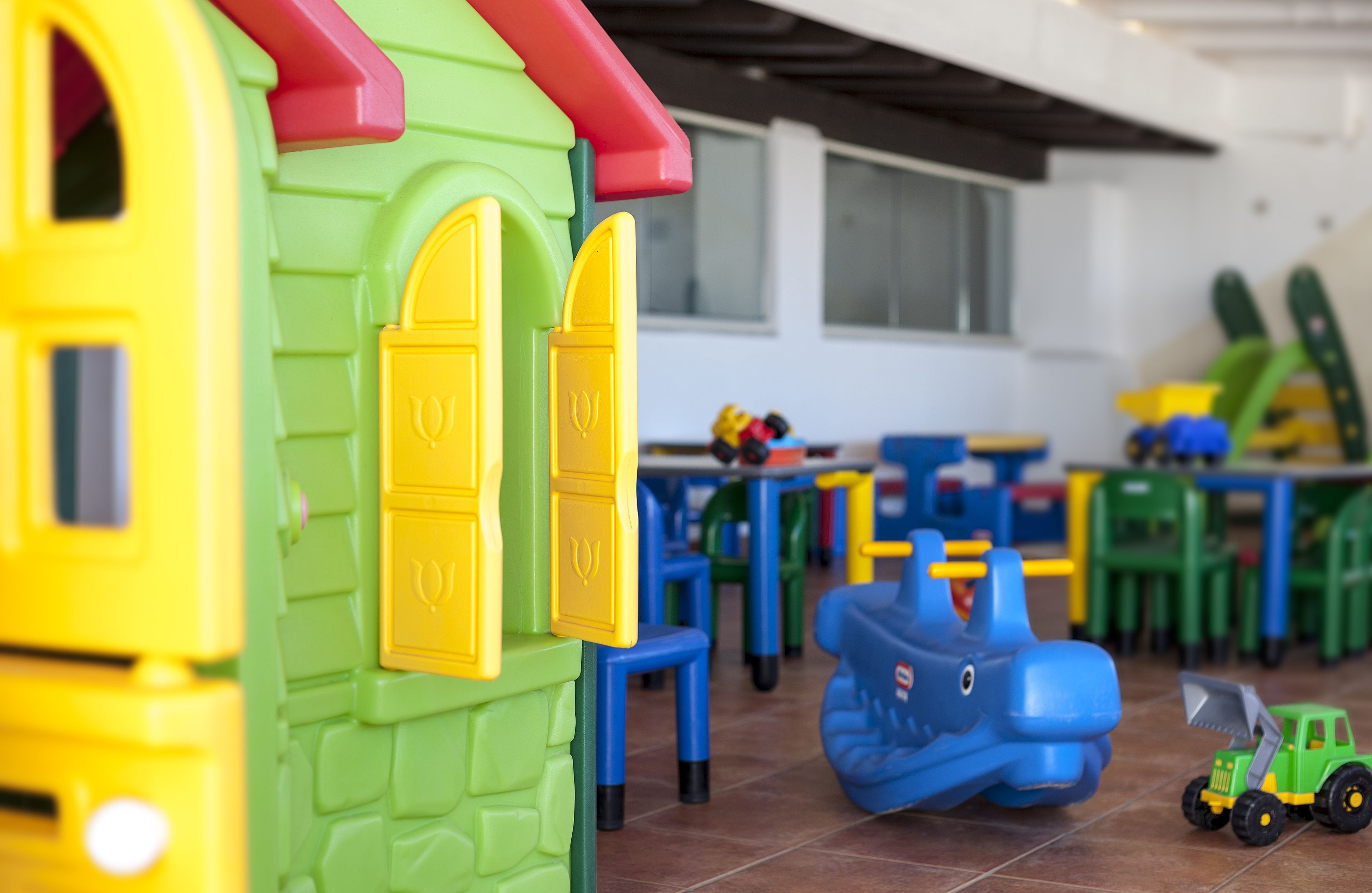 Un área de juegos infantiles con juguetes y muebles de plástico de colores.