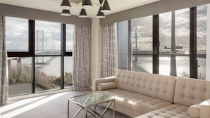A modern living room with a large window offering a view of a bridge and water. - DoubleTree by Hilton Edinburgh - Queensferry Crossing (Dunfermline)