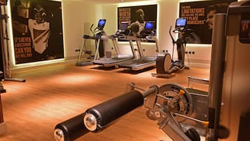 A gym with treadmills, elliptical machines, and a cable machine.
