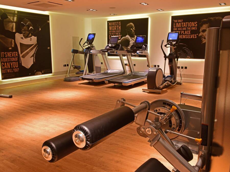 A gym with treadmills, elliptical machines, and a cable machine.