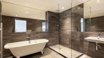 A modern bathroom with a freestanding bathtub, a glass-enclosed shower, and a vanity with a sink.