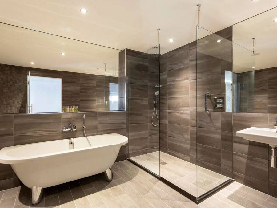 A modern bathroom with a freestanding bathtub, a glass-enclosed shower, and a vanity with a sink.