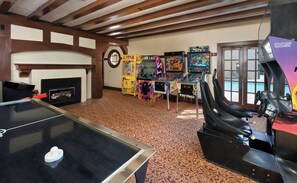 A room with a ping pong table, arcade games, a dartboard, and a fireplace. - WorldMark Clear Lake (Nice)