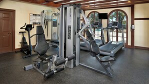 A gym with various exercise equipment, including a treadmill, elliptical, and weight machines. - WorldMark Clear Lake (Nice)