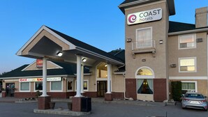 A hotel with a sign for 'COAST hotels' and a 'Kimchi House Korean Restaurant' adjacent to it. - Coast Hinton Hotel (Hinton)
