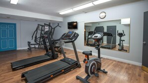 A gym with treadmills, a stationary bike, and weight machines. - Coast Hinton Hotel (Hinton)