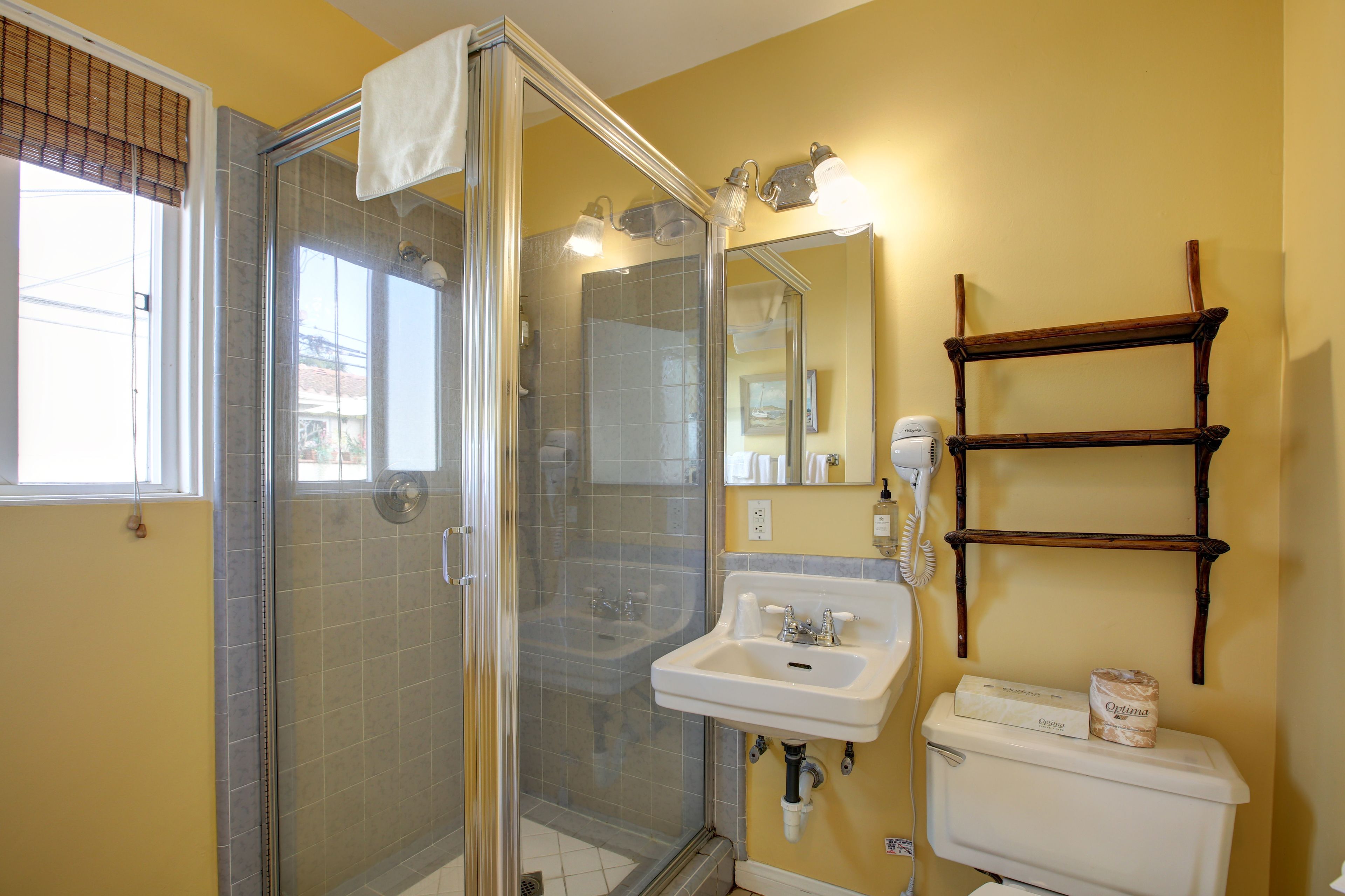 Een badkamer met douche, wastafel, toilet en een houten plank.