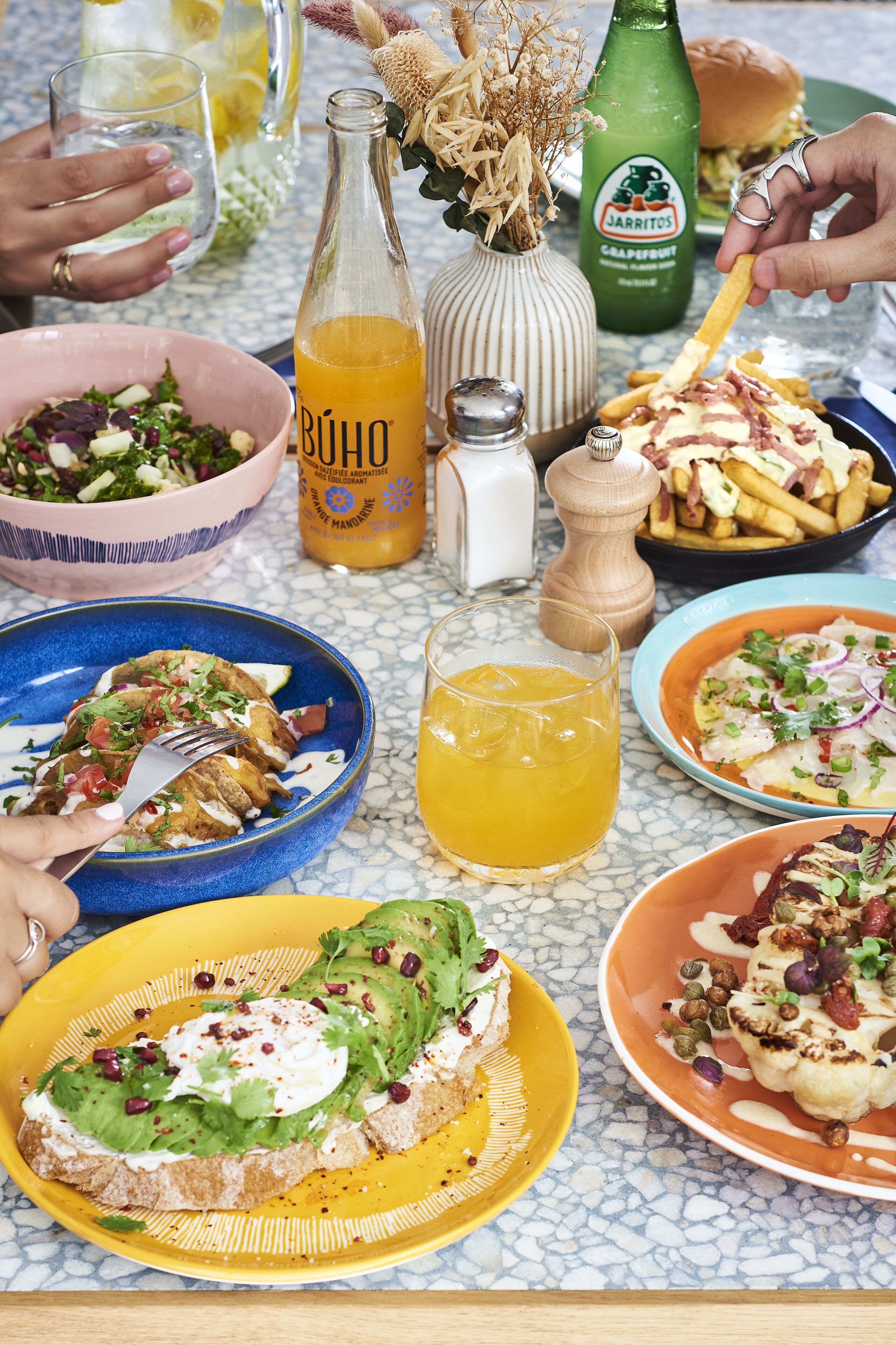A table with various dishes, drinks, and condiments.