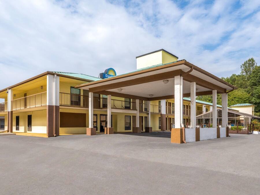 A motel with a covered parking area, multiple balconies, and a Shell gas station sign.
