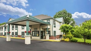 A two-story building with a covered entrance and a sign indicating an indoor pool.