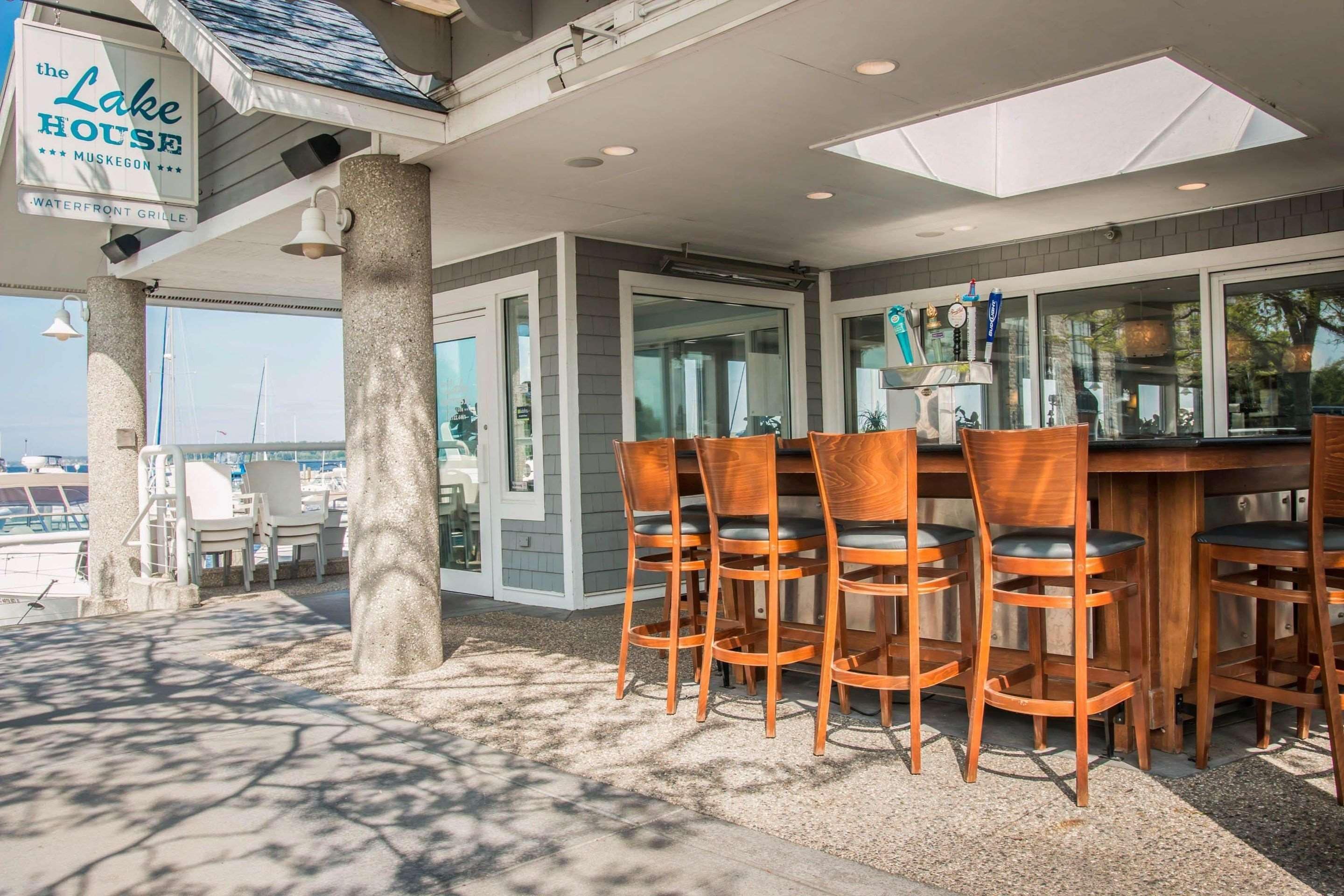 An outdoor seating area with a bar, wooden chairs, and a sign for 'The Lake House'.