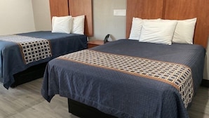 Two single beds with wooden headboards, a nightstand, and a patterned bedspread. - Motel 6 Putnam, CT (Putnam)