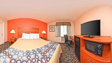 Een hotelkamer met een bed, televisie, bureau en een magnetron.