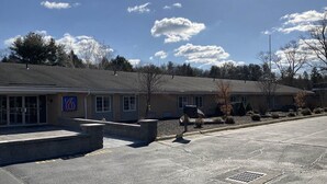 A building with a sign indicating a number six. - Motel 6 Putnam, CT (Putnam)