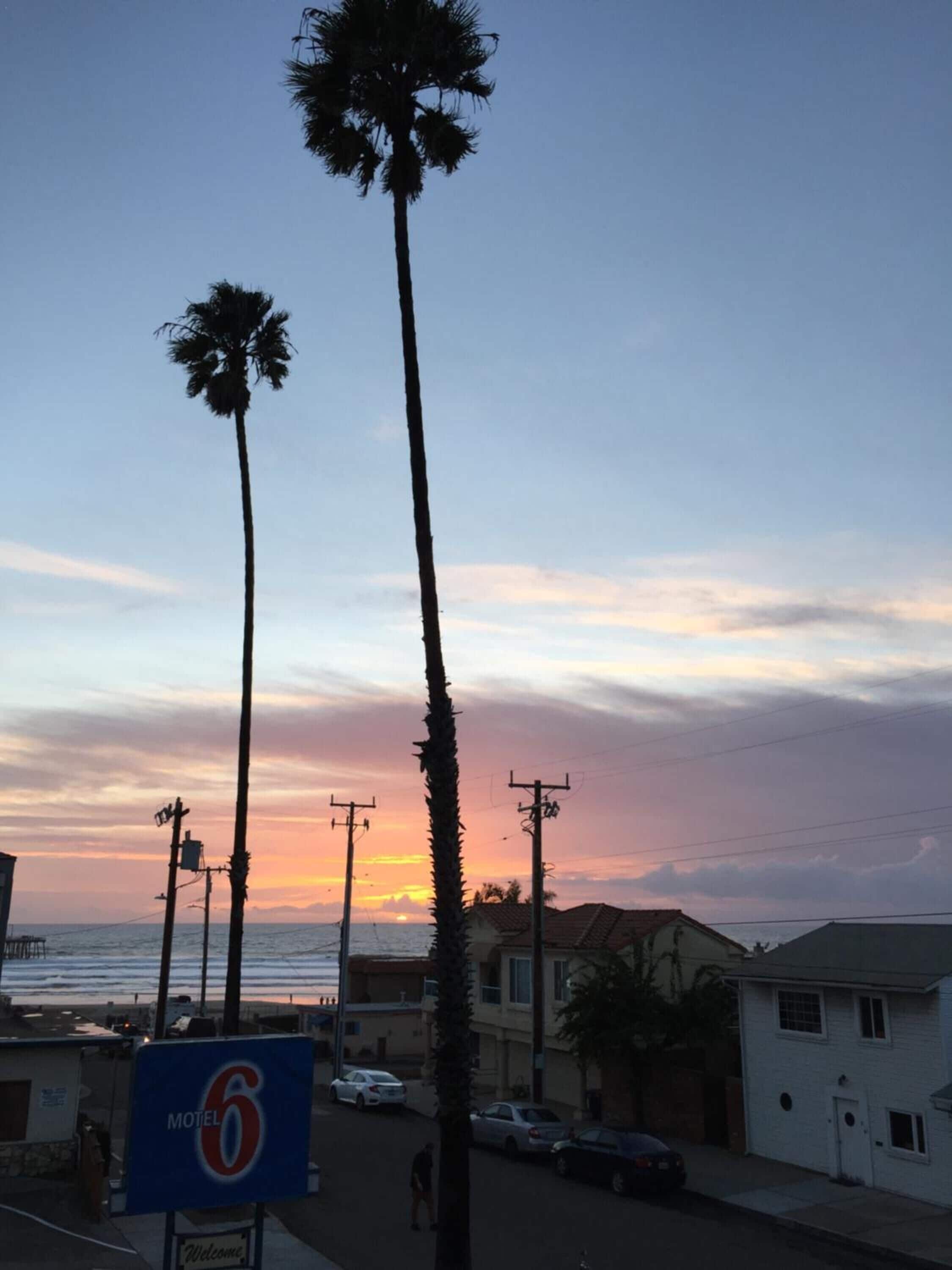 A motel sign with a sunset view.