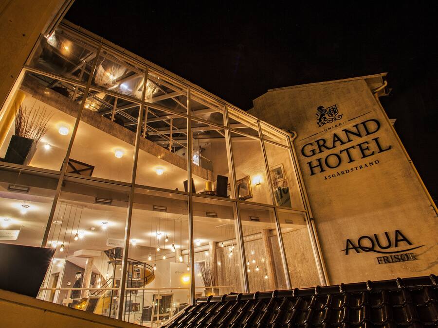 Un hotel con un cartel llamativo que dice 'Grand Hotel' y 'Aqua Frisoir'.