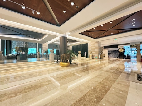 A spacious lobby with a marble floor, a reception desk, and a large decorative elephant sculpture.. voco Changzhou Fudu by IHG