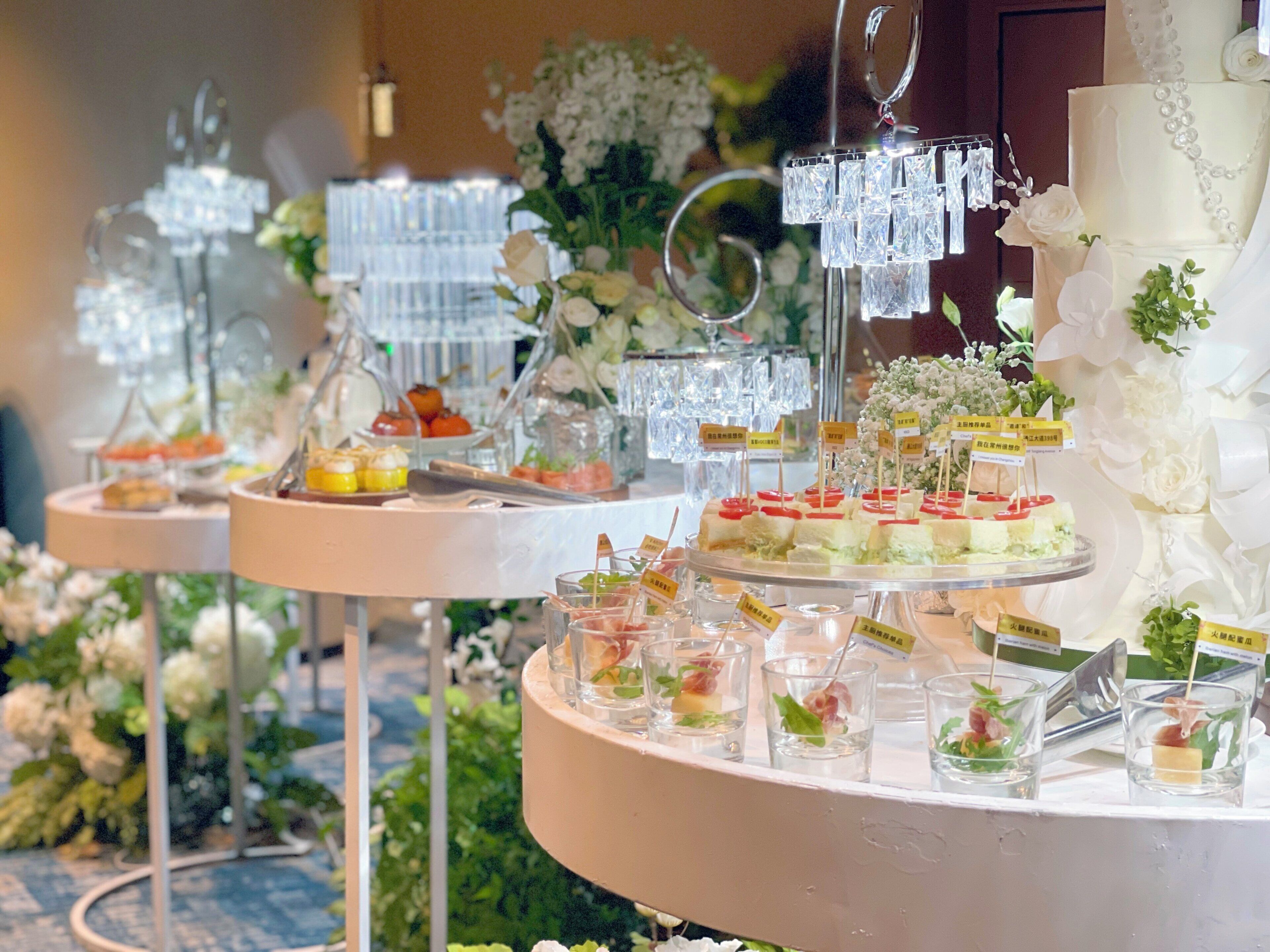 A buffet setup with various food items and clear glassware.