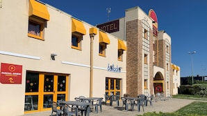 A hotel with outdoor seating and a clear sky. - Brit Hotel Essentiel Tours Sud – Chambray-lès-Tours  (Chambray-les-Tours)