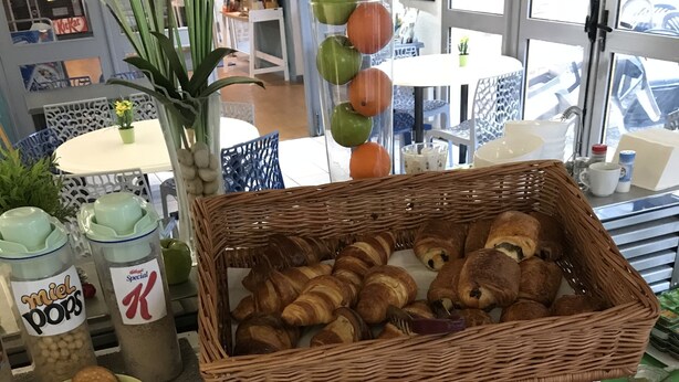 A bakery display with various baked goods, including croissants and cookies, arranged on a counter. - Brit Hotel Essentiel Tours Sud – Chambray-lès-Tours  (Chambray-les-Tours)