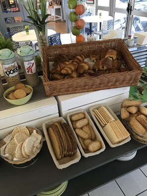 Une vitrine de boulangerie présentant diverses pâtisseries, notamment des croissants et des biscuits, disposés sur un comptoir.