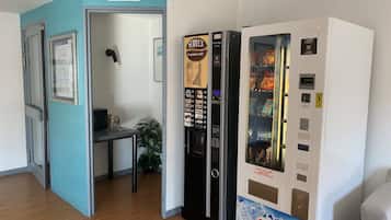 A room with a vending machine, a microwave, and a refrigerator.