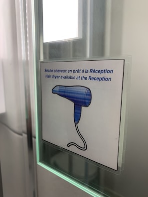 Een bord dat aangeeft dat er een haardroger beschikbaar is bij de receptie.