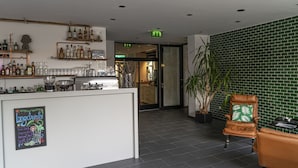 A bar area with shelves of liquor bottles, a coffee machine, and a sign that reads "Longdrinks." -  BIG MAMA Leipzig (Leipzig)