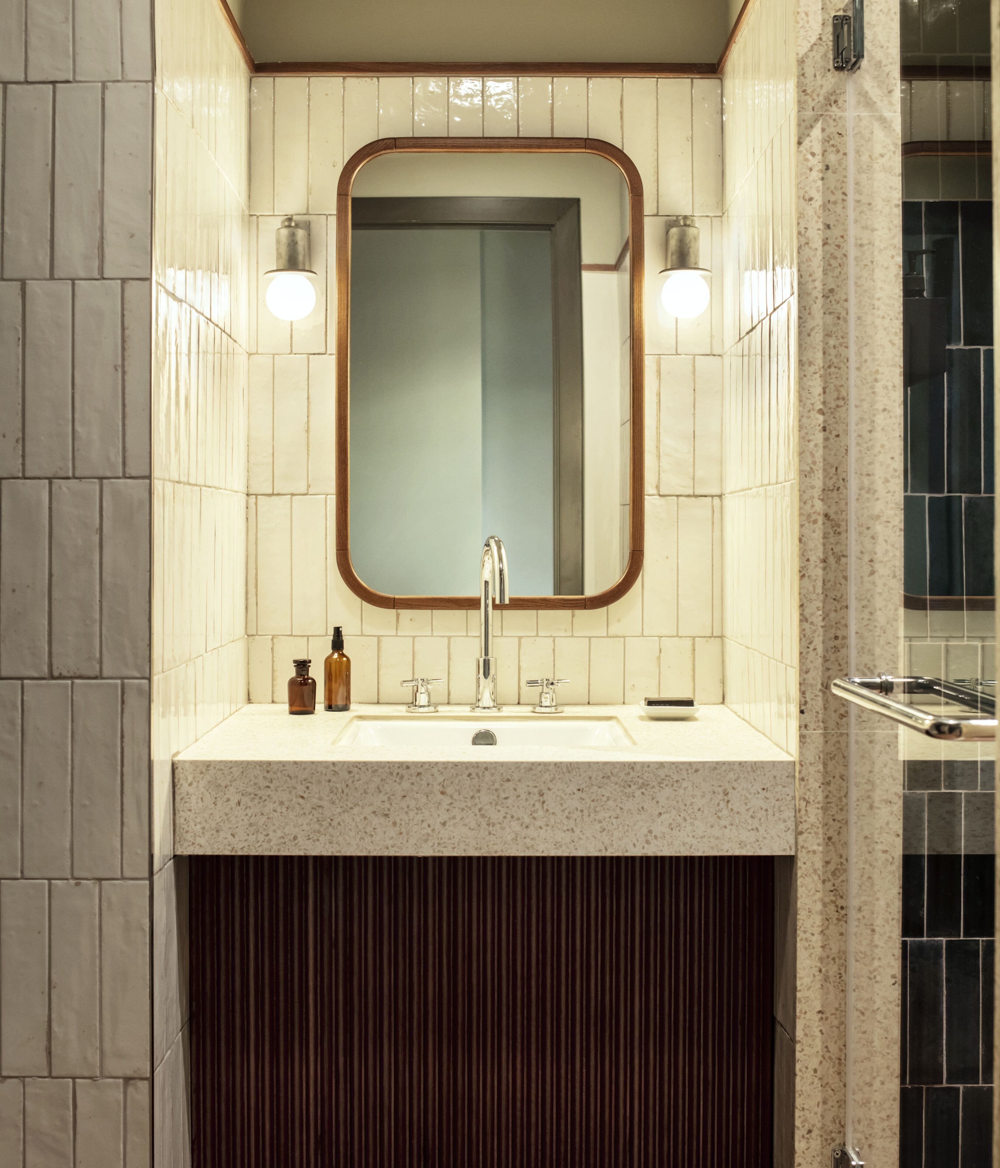 A bathroom with a sink, mirror, and two wall-mounted lights.