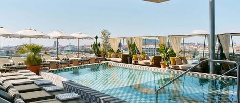 Una piscina al aire libre, tumbonas