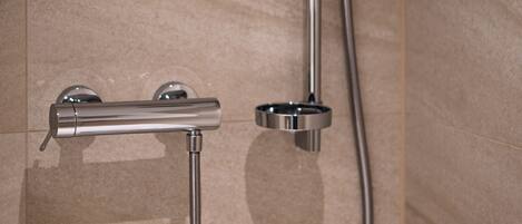 A shower with a handheld showerhead and a handheld faucet.