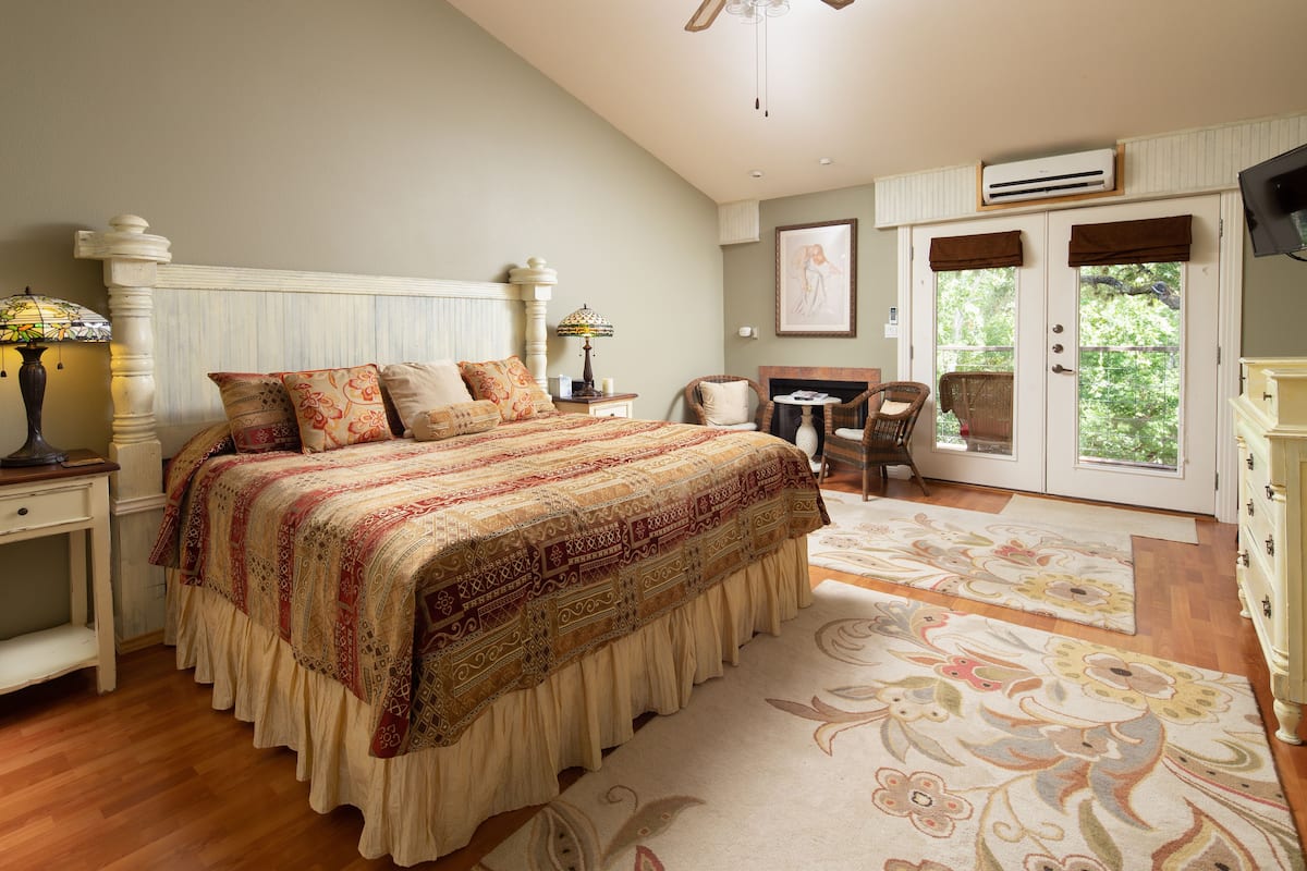 A bedroom with a large bed, a desk, and a chair.
